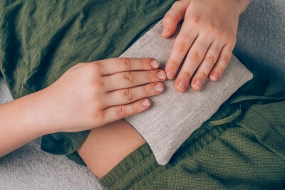 A boy using a grain pillow on his stomach