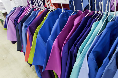 Colorful surgery wear hangs on hangers.