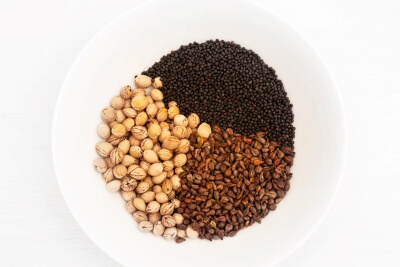 Rapeseed, cherry pits, and grape seeds in a bowl for filling a grain pillow