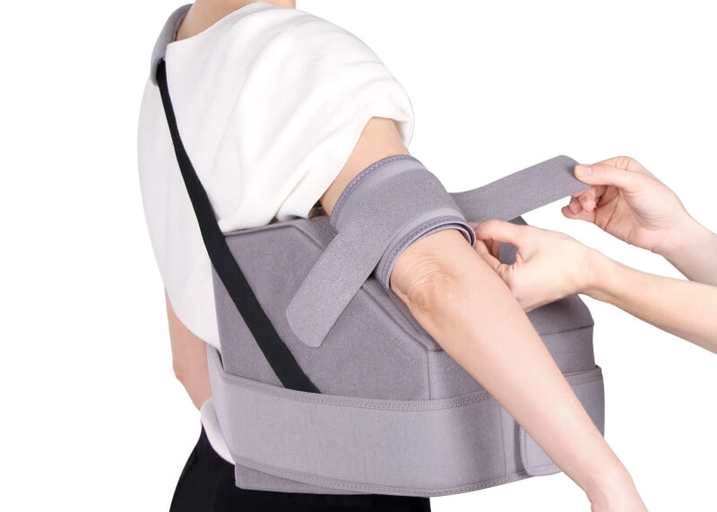 A patient wearing an abduction orthosis for immobilization with an abducted arm