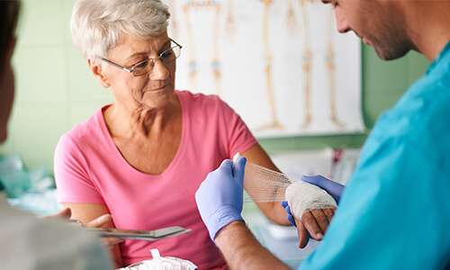 Buy zinc paste bandages A person applying a zinc paste bandage to an elderly woman