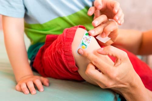 Colorful children's plaster applied to a child's knee