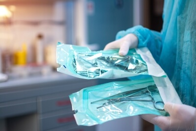 Close-up of a dentist holding dentistry tools in a protective film Dentist holding dentistry tools in protective film