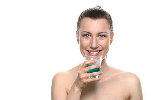 Woman with a glass of mouth rinse